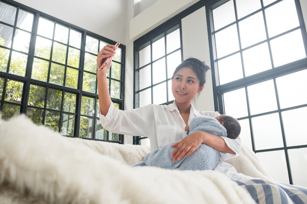 Las madres adolescentes y los bebés están tomando selfies.