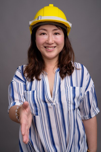 madura empresária asiática bonita usando capacete de segurança