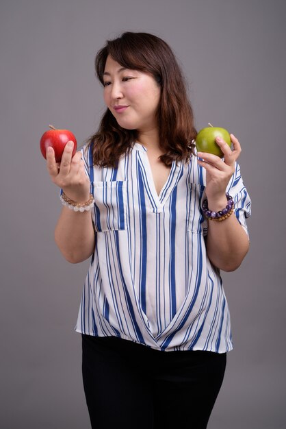 Madura hermosa empresaria asiática sosteniendo manzanas