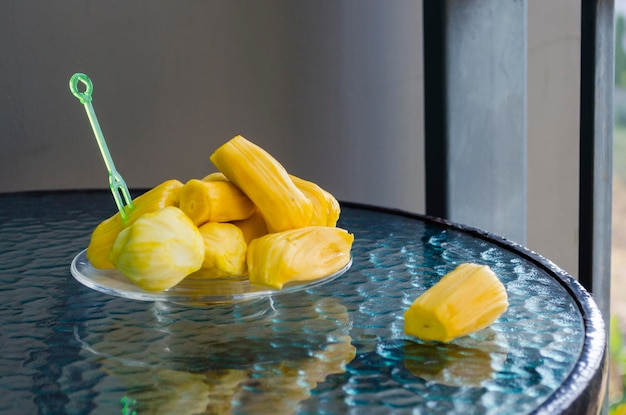 Maduras, jugosas, aromáticas, deliciosas frutas peladas de color amarillo brillante de la fruta del pan indio en una mesa de vidrio