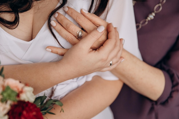 Mãe abraça filha no dia do casamento Mãos fechadas Abraços calorosos da família