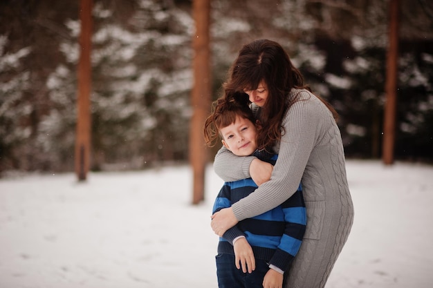 Mãe abraça filho em dia de inverno passando tempo juntos