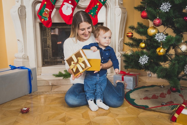 Mãe abraçando seu filho na árvore de Natal