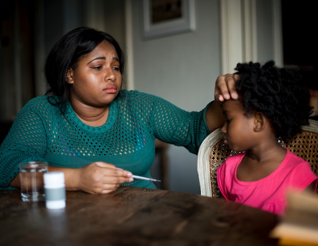 Mãe africana, cuidando de sua filha doente