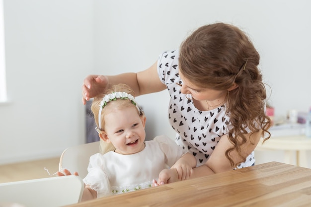 Mãe ajuda a colocar implante coclear para sua filha surda Conceito de aparelho auditivo e surdez