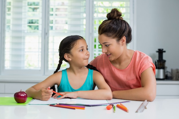 Mãe, ajudando a filha a fazer a lição de casa