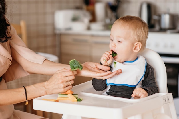 Mãe ajudando o bebê a escolher que comida comer