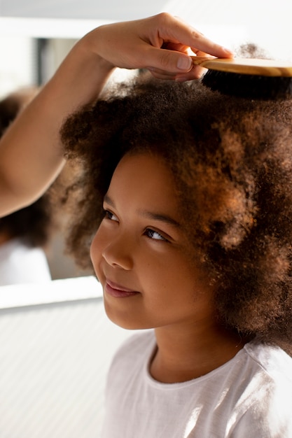 Foto mãe ajudando seu filho a pentear o cabelo afro