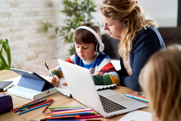 Mãe ajudando seu filho enquanto estuda em casa