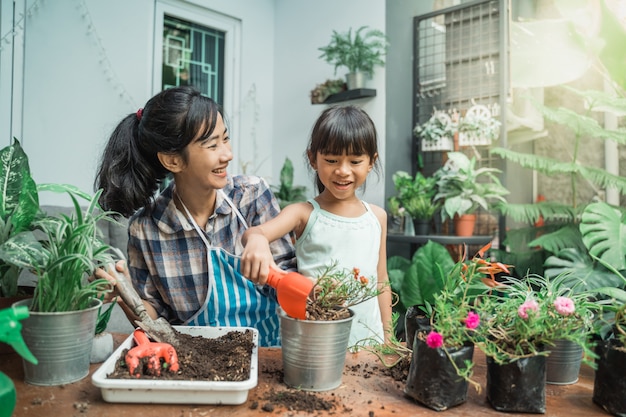 Mãe alegre e filha durante o plantio