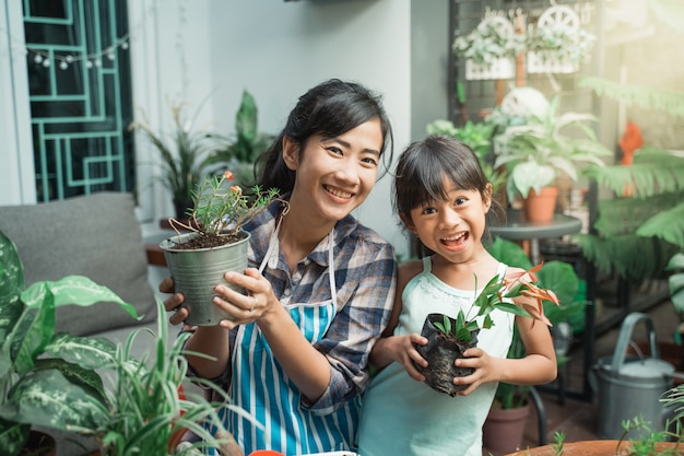 Mãe alegre e filha durante o plantio