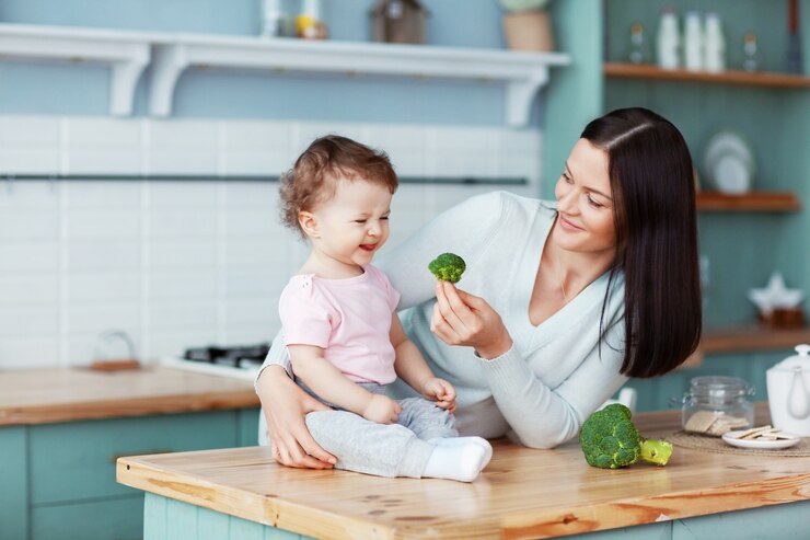 Mãe alimenta bebê brócolis e legumes
