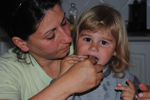 Mãe alimentando a filha bonita em casa