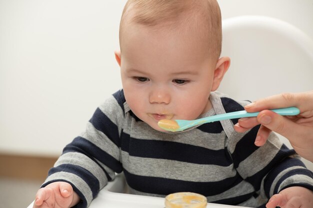 Mãe alimentando bebê com colher