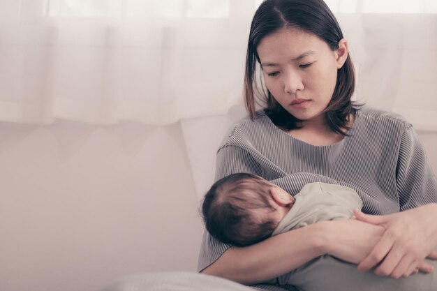 Foto mãe alimentando o bebê enquanto está sentada na cama em casa