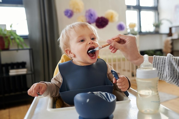 Foto mãe alimentando seu bebê com mingau