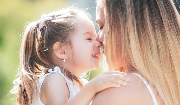 Mãe ama mãe e criança menina brincando de beijar e abraçar a filha abraçando sua mãe feliz