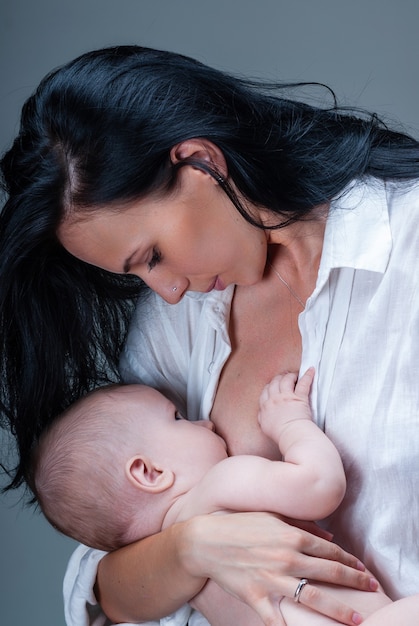 Foto mãe amamentando e abraçando seu bebê