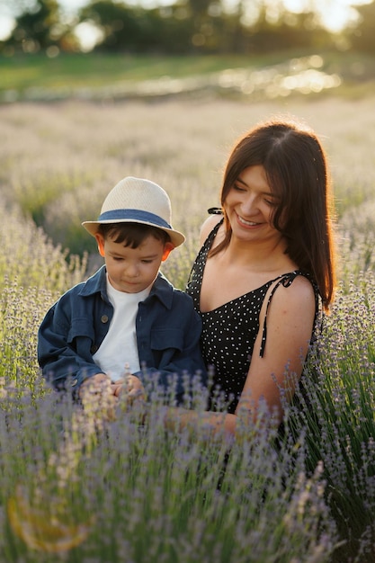 Mãe amorosa com seu filho está brincando no campo com lavanda