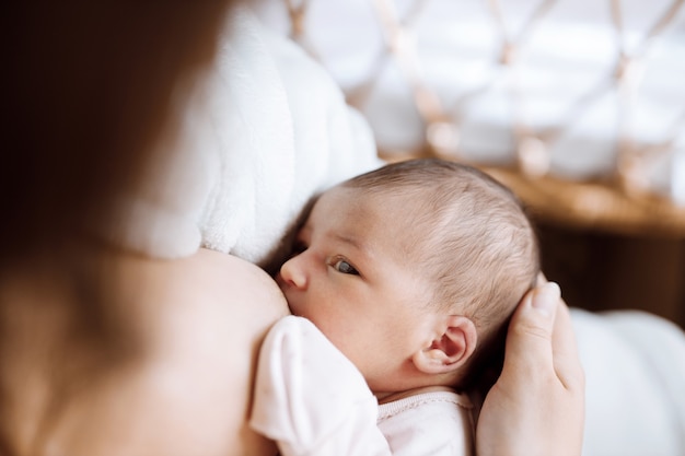 mãe amorosa cuidando de seu bebê recém-nascido, comendo leite materno