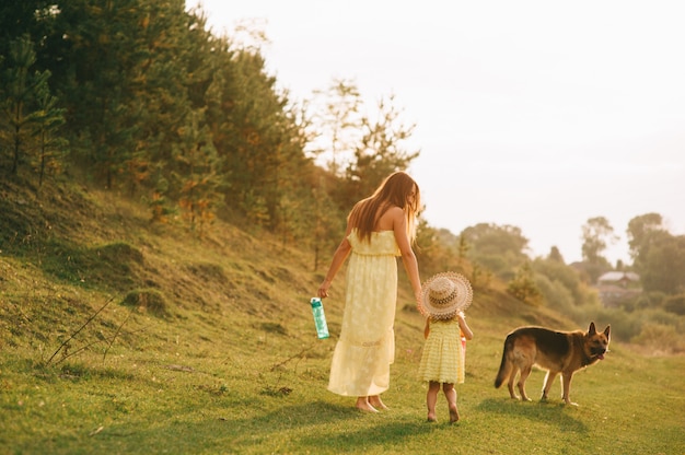 mãe anda com sua filhinha e seu cachorro