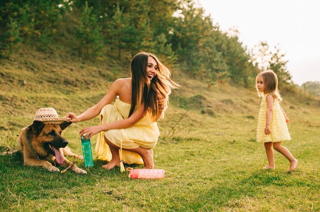 Mãe anda com sua filhinha e seu cachorro