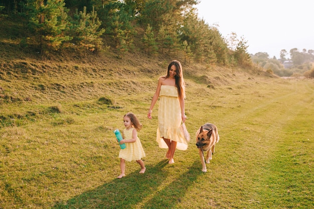 Mãe anda com sua filhinha e seu cachorro