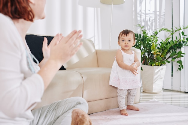 Mãe aplaudindo sua menininha dançarina quando eles estão ficando em casa devido à pandemia