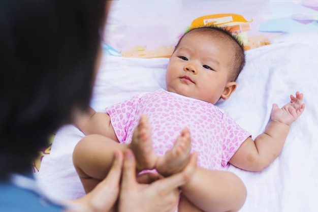 Mãe asiática, brincando e cuidando do bebê no parque