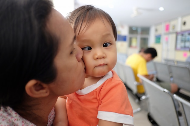 Mãe asiática, carregando um bebê.