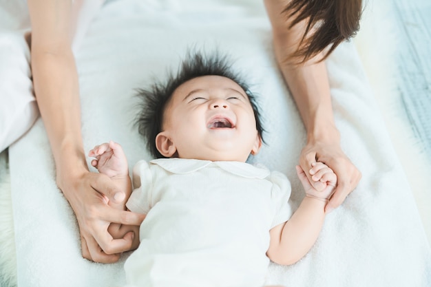 Mãe asiática e bebê brincando dentro de casa