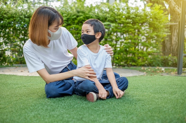 Mãe asiática e seu filho vestindo máscaras protetoras