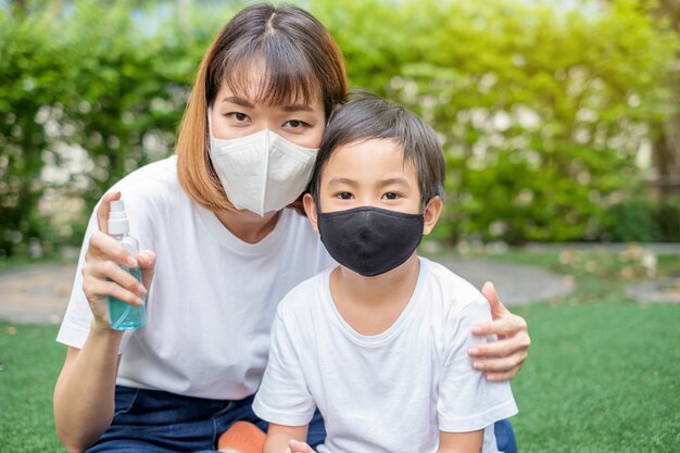 Mãe asiática e seu filho vestindo máscaras protetoras