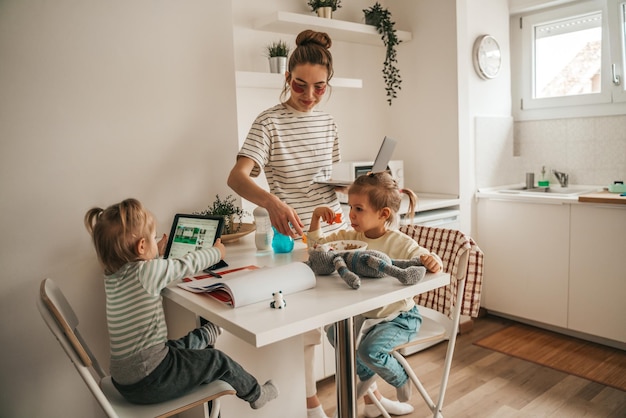 Foto mãe autônoma e suas filhas na cozinha