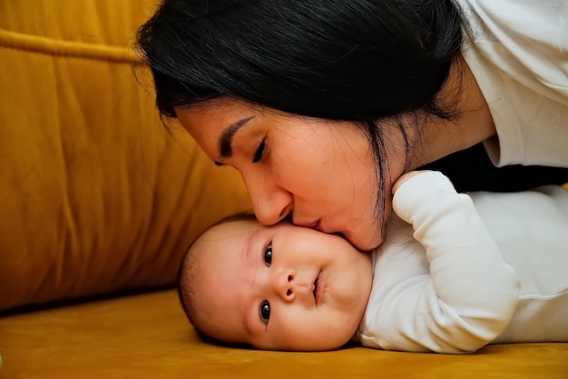 Mãe beija a bochecha de um recém-nascido o conceito de um beijo amor maternal