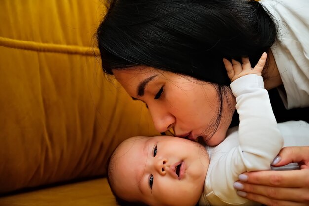 Mãe beija a bochecha de um recém-nascido o conceito de um beijo amor maternal