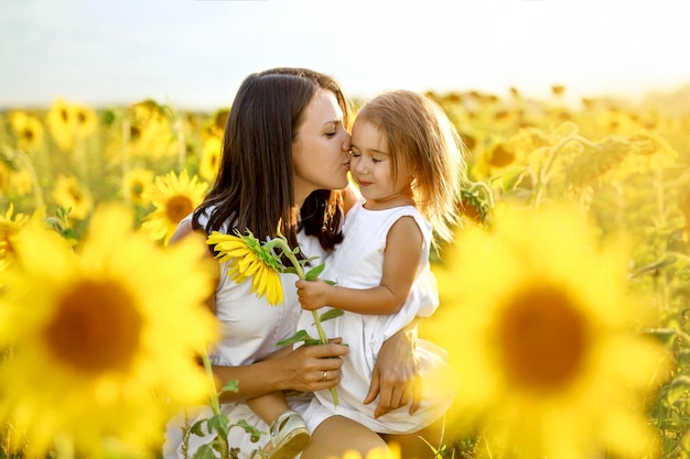 Mãe beija suavemente sua filhinha em gratidão pelo presente de um girassol