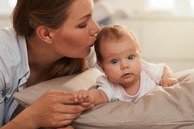 Mãe beijando bebê adorável