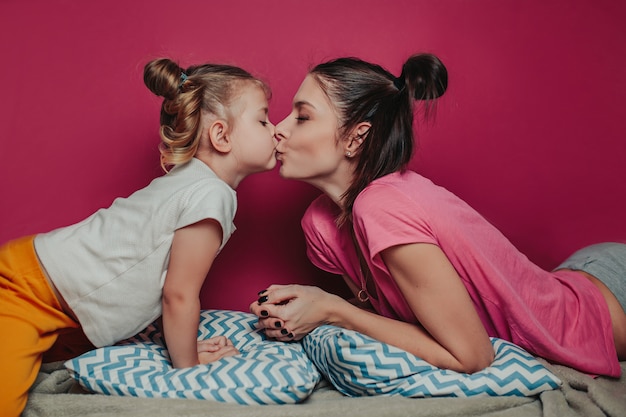 Mãe beijando filha.