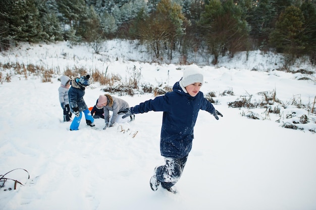 Mãe brincando com crianças na natureza de inverno ao ar livre na neve