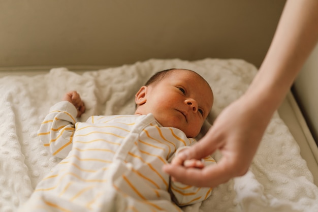 Mãe brincando com o filho recém-nascido em casa