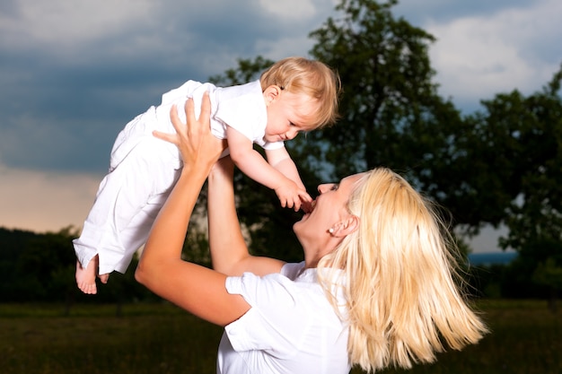 Mãe brincando com seu bebê ao ar livre