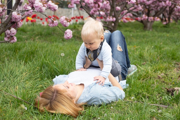 Mãe brincando com um filho bebê na primavera maternidade e feminilidade