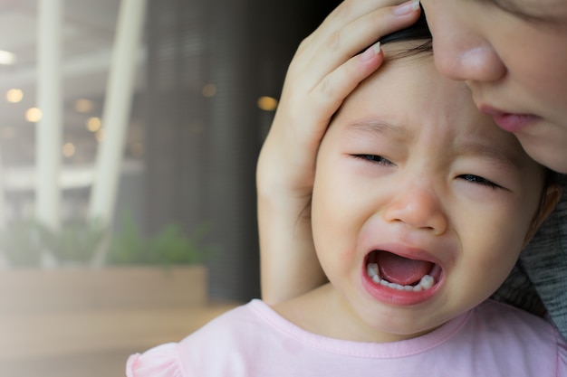 Foto mãe calmante menina chorando.