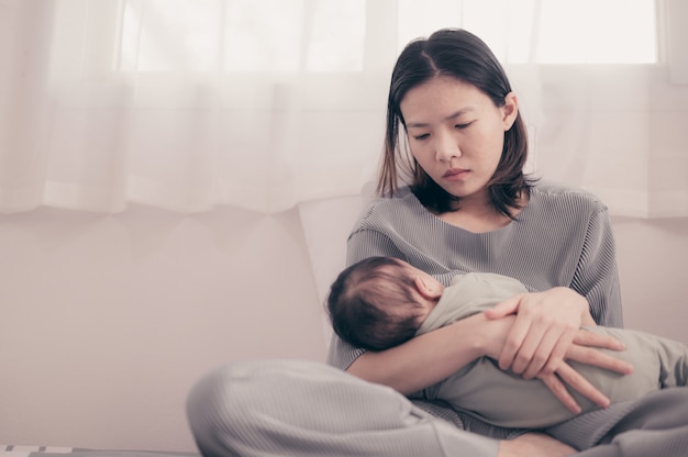 Mãe cansada, sofrendo de depressão pós-natal. Cuidados de saúde mãe solteira maternidade estressante.