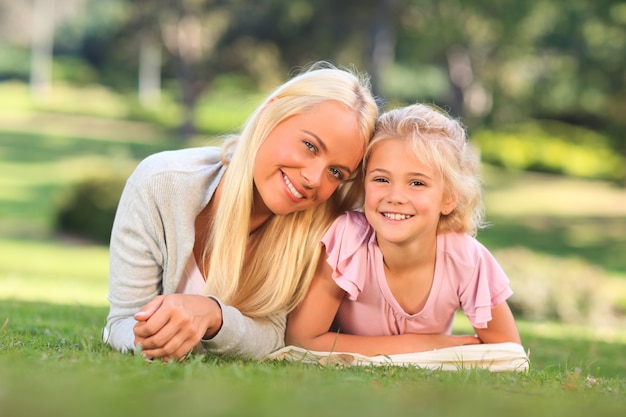 Mãe com a filha deitada no parque