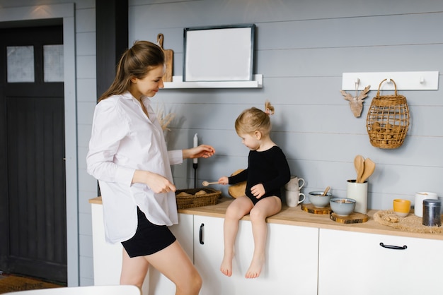 Mãe com a filha na cozinha cozinhando juntas