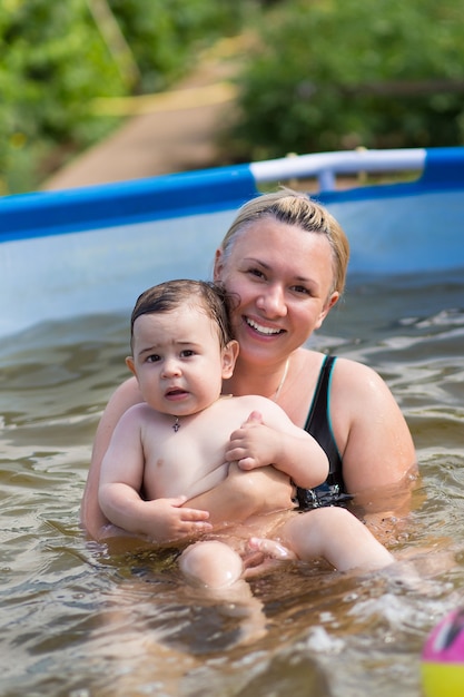 Foto mãe com bebê se divertindo na piscina.