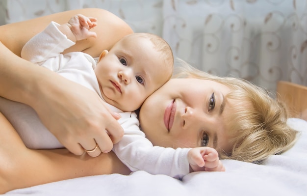 Mãe com bebê sobre um fundo claro. Foco seletivo. Pessoas.