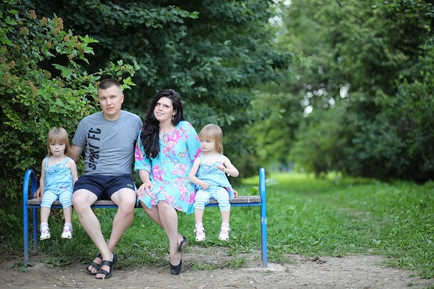 Mãe com duas filhas gêmeas para passear no parque